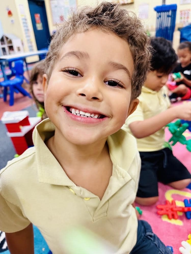 Smiling preschool child in a classroom environment during a learning activity