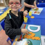 Preschool child engaged in hands-on learning activity at a classroom table