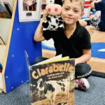 Preschool child holding a book during early literacy activity