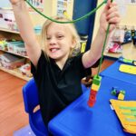 Excited preschool child celebrating during classroom learning activity