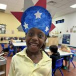 Preschool child smiling in classroom during creative dress-up activity